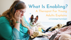 young adult looking at computer sitting in bed